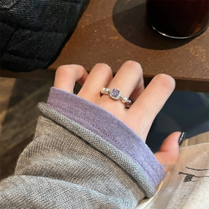 Elegant beaded ring featuring a square purple zircon and pearls on a textured background