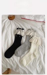 Close-up of adult fashion socks with lace trim and bow details in three colors