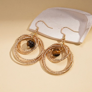 Bohemian gold layered hoop earrings with tiger eye stone on a minimalist stone base
