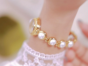Close-up of luxury gold pearl bracelet watch for women featuring elegant chain link design