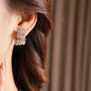 Gros plan de boucles d'oreilles carrées en zircone argentée avec cristaux brillants