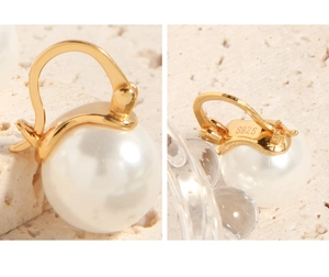 Macro view of S925 sterling silver hallmark and white pearl on golden hoop earring