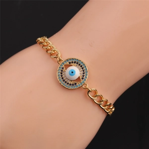 Detailed view of evil eye bracelet with gold chain and blue zircon pendant on wrist