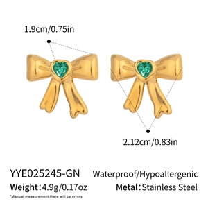 Detail view of gold bow earrings with green heart zircon and size dimensions