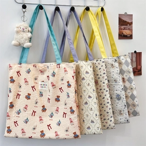 Detail shot of five diverse canvas tote bags with cute puppy and floral prints on hooks