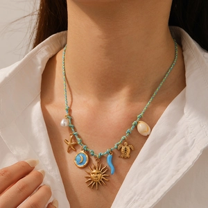 Close-up of a blue woven ocean necklace with starfish, turtle and shell pendants
