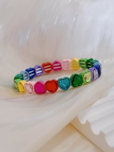 Detalle de cerca de cuentas de corazón macaron y cristales brillantes en pulsera elástica