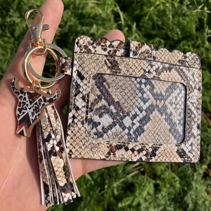 Detail of snake pattern PU card holder with tassel and ox head pendant on keychain