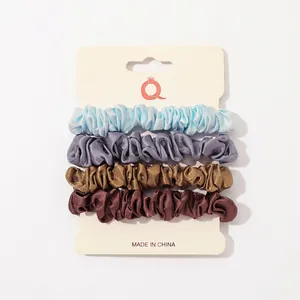 4-pack satin silk scrunchies in blue, grey, bronze, and brown on display card