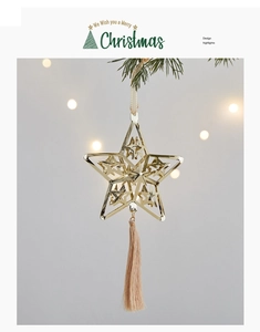 Golden star-shaped Christmas ornament with tassel hanging on a pine branch