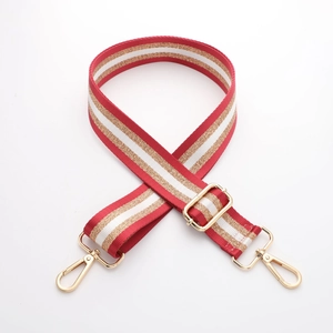 Close-up of adjustable red, gold and white striped canvas strap with gold metal buckles