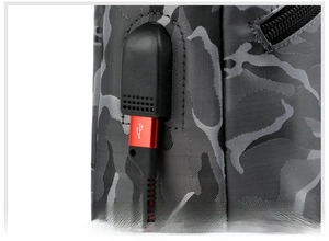 Détail d'un sac de poitrine camouflage avec port USB externe et câble de chargement