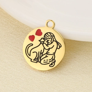 Detail of 18k gold pendant featuring dog hug design and red enamel heart charms