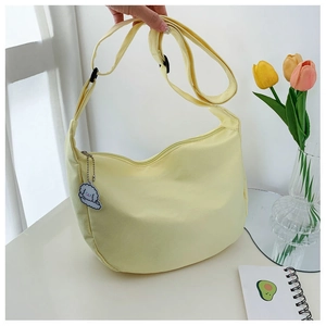 Top view of bright yellow dumpling bag with cute lamb charm and tulip decor