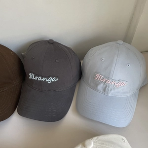 Close-up of Hiranga embroidery detail on cotton baseball caps in multiple colors