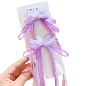 Pair of purple ribbon bow hair clips with long streamers for girls on display card