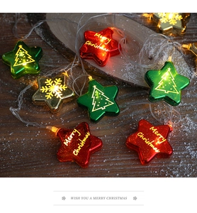 Close-up of star-shaped Christmas LED lights with Merry Christmas prints on wooden surface