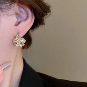 Close-up of double-sided diamond flower opal earrings worn to show the luxury petal details