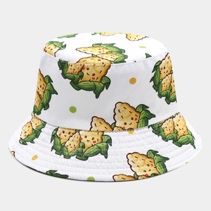 Detail of white reversible bucket hat featuring cute cartoon corn and polka dot prints