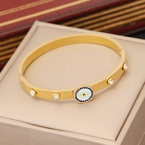 Gold evil eye bracelet with sparkling rhinestones displayed on a jewelry stand