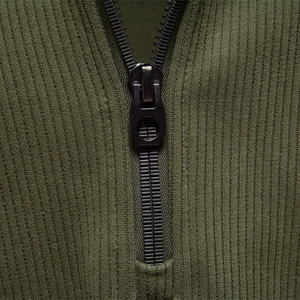 Close-up of olive green half-zip sweatshirt with ribbed knit texture and metal zipper