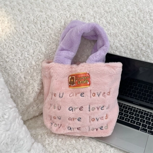 Détail du sac en peluche avec broderie colorée 'you are loved' et écusson d'ours mignon