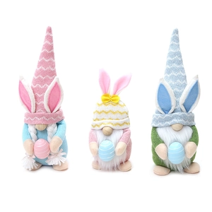 Tres gnomos de Pascua de peluche con orejas de conejo y huevos para decoración festiva
