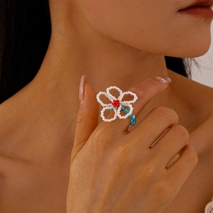 Detailed view of a handmade beaded flower ring with red, white, and blue glass beads