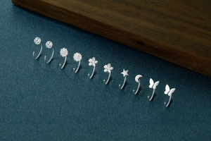 Macro shot of 999 sterling silver stud earrings featuring stars, moons and butterflies