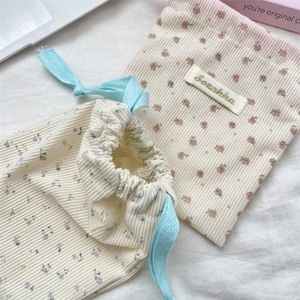 Detail of corduroy floral and cherry drawstring storage bags for cosmetics and travel