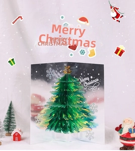 Detail of 3D pop-up Christmas card showing a green and gold tree on a white background