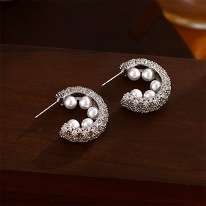French vintage silver needle C-shaped earrings with zircons and pearls on wood