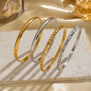 Set di 4 bracciali rigidi martellati e lisci in oro 18K e argento su pietra naturale