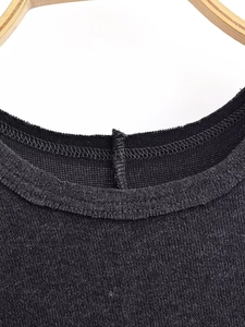 Detail of black knit dress neckline featuring fine fabric texture and double-stitch seams