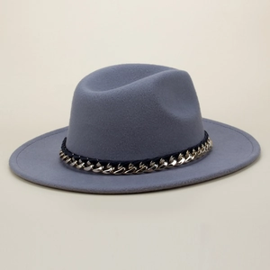 Close-up detail of a grey wool fedora hat with a decorative gold chain and black ribbon band.
