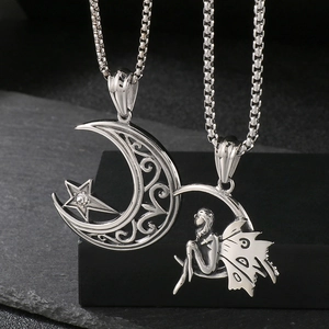 Macro detail of silver moon and fairy pendants with elegant box chain on dark stone