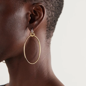 Two-tone stainless steel hoop earrings in gold and silver finish on a female model