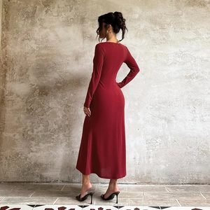 Back view of a slim-fit burgundy long-sleeve knit dress against a grey textured wall