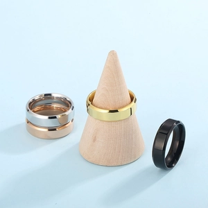 Polished stainless steel rings in gold, silver, rose gold and black on a wood display