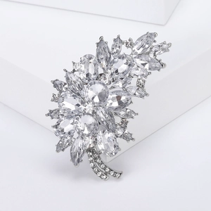 Exquisite silver flower cluster brooch detail with sparkling zircons on white pedestal