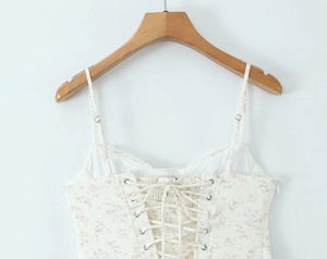 Détail du dos d'une robe fleurie avec dentelle et lacets croisés ajustables à la taille