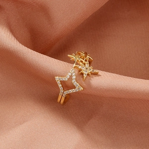 Close-up of gold star ear cuff with white zircon stones on luxury silk background