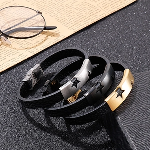 Detail of black leather punk bracelets with star-engraved brushed stainless steel clasps