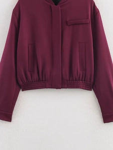 Detail der burgunderroten Bomberjacke mit elastischem Saum und glatter Stoffstruktur