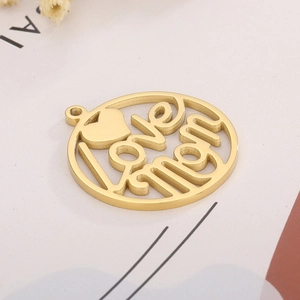 Close-up of golden Love Mom hollow pendant charm with heart detail for DIY jewelry