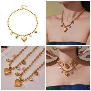 Vue détaillée du collier perlé plaqué or 18 carats avec pendentifs cœur et ours