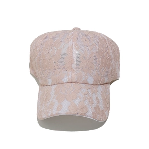 Dettaglio della trama in pizzo floreale rosa su un cappello da baseball traspirante