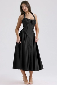 Detail of a black halter midi dress with a fitted bodice and tiered ruffled hemline