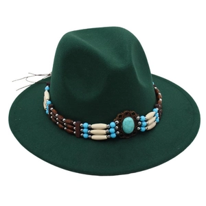 Detailed shot of ethnic braided band with turquoise beads on green wool fedora hat