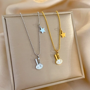 Titanium steel necklace with gold and silver rabbit star pendants on a silk background